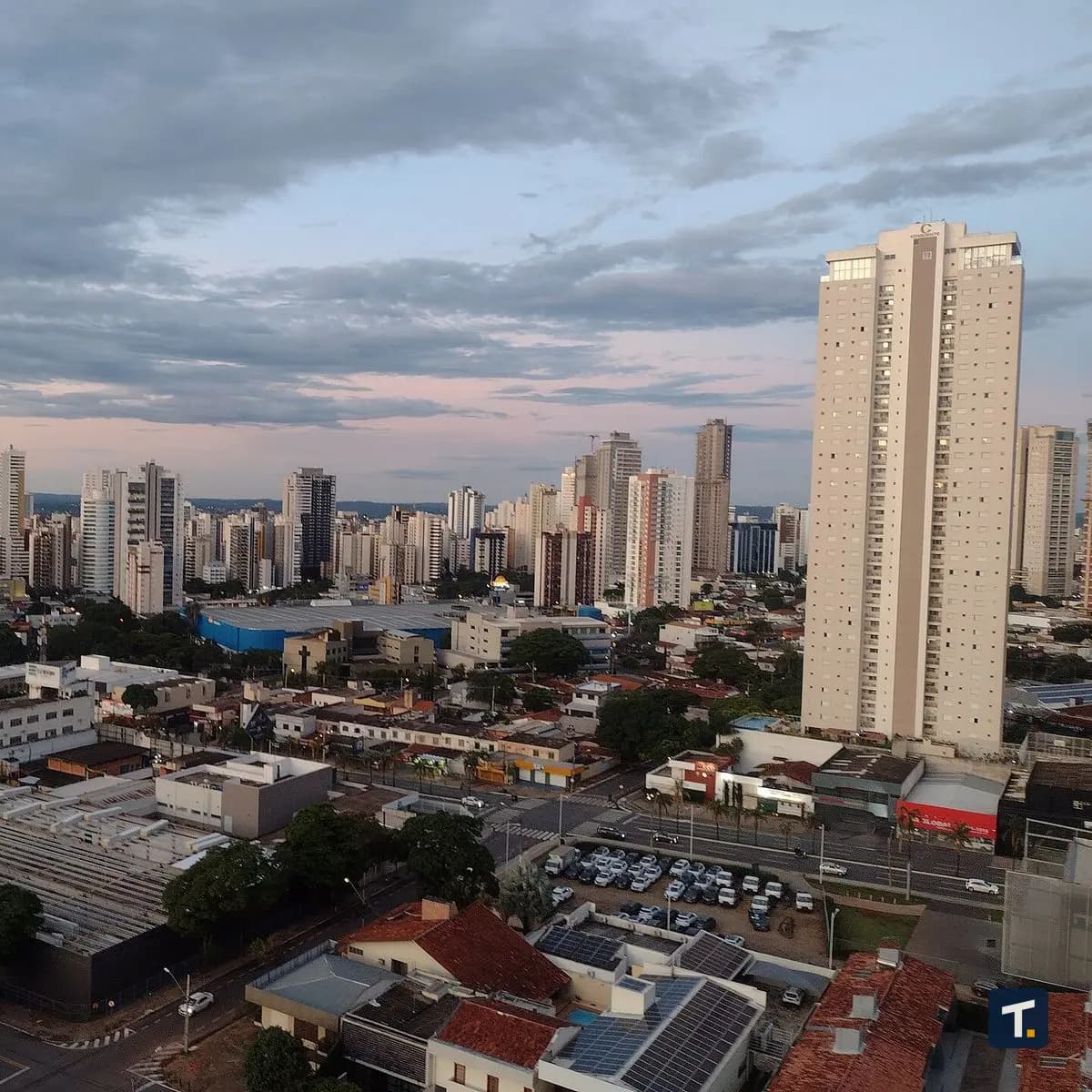 Mesa de escritório moderna com laptop exibindo gráficos de vendas e caderno de anotações em Goiânia.
